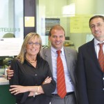 Nella foto grande, l’ingresso della filiale di Olcella in via dei Mille. Qui in alto, lo staff dello sportello: da sinistra, Antonia Verrini, il responsabile Salvatore Bruno e Maurizio Binaghi