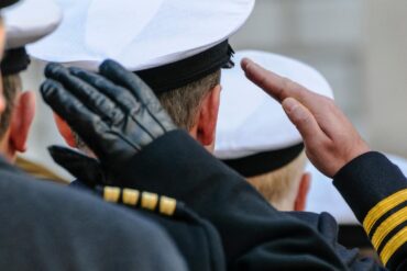 attenti Gli ufficiali della Royal Navy salutano durante le commemorazioni del Giorno della Memoria.